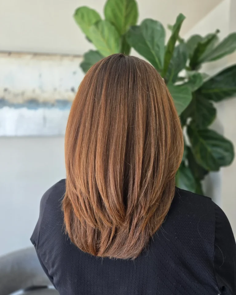 back view of a client's layered brunette hair after grey blending hair color